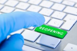Hand ready to push Keyboard with green key and text Reopening